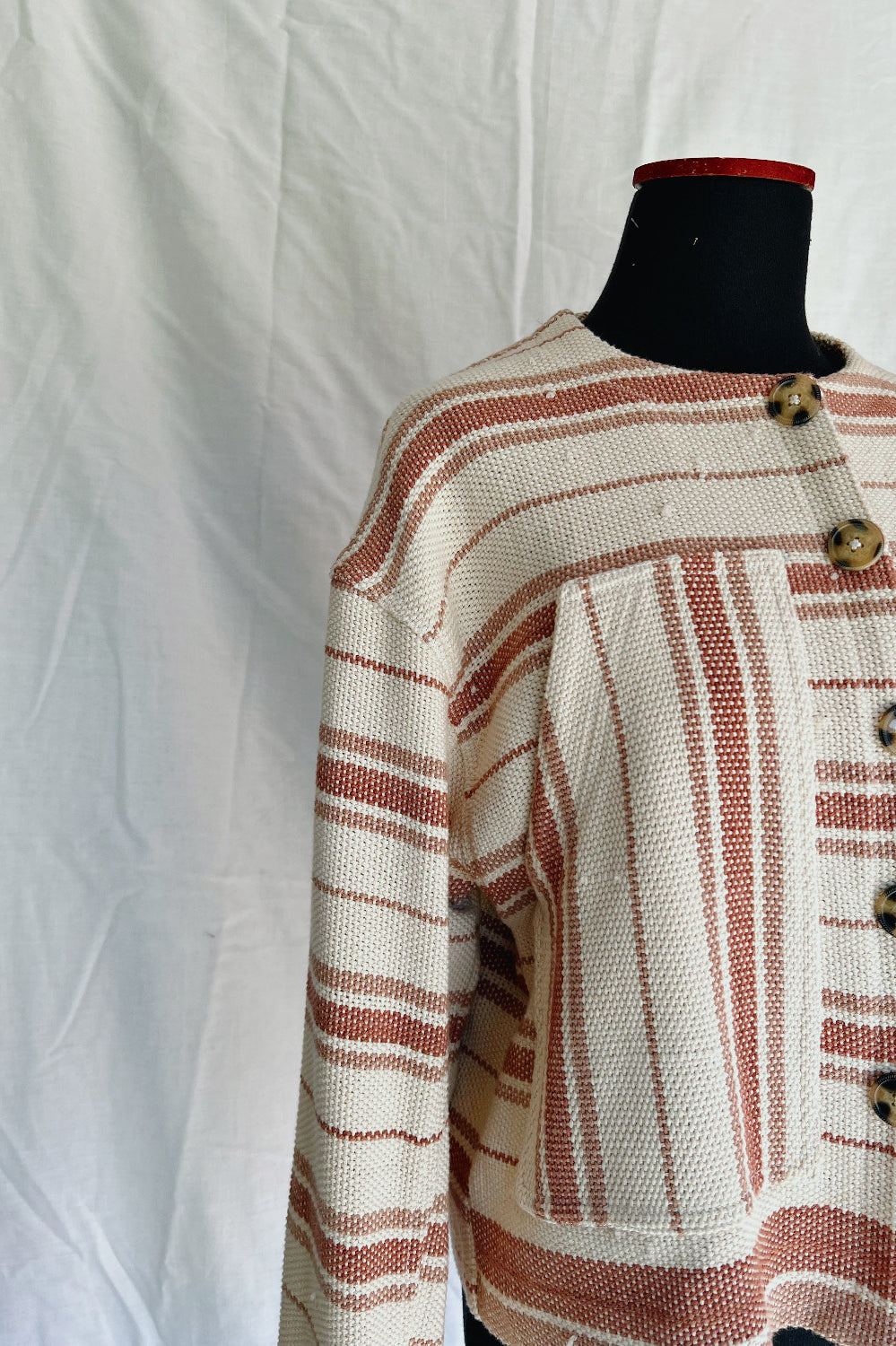 Textured jacket with striped pattern on a mannequin against a white background
