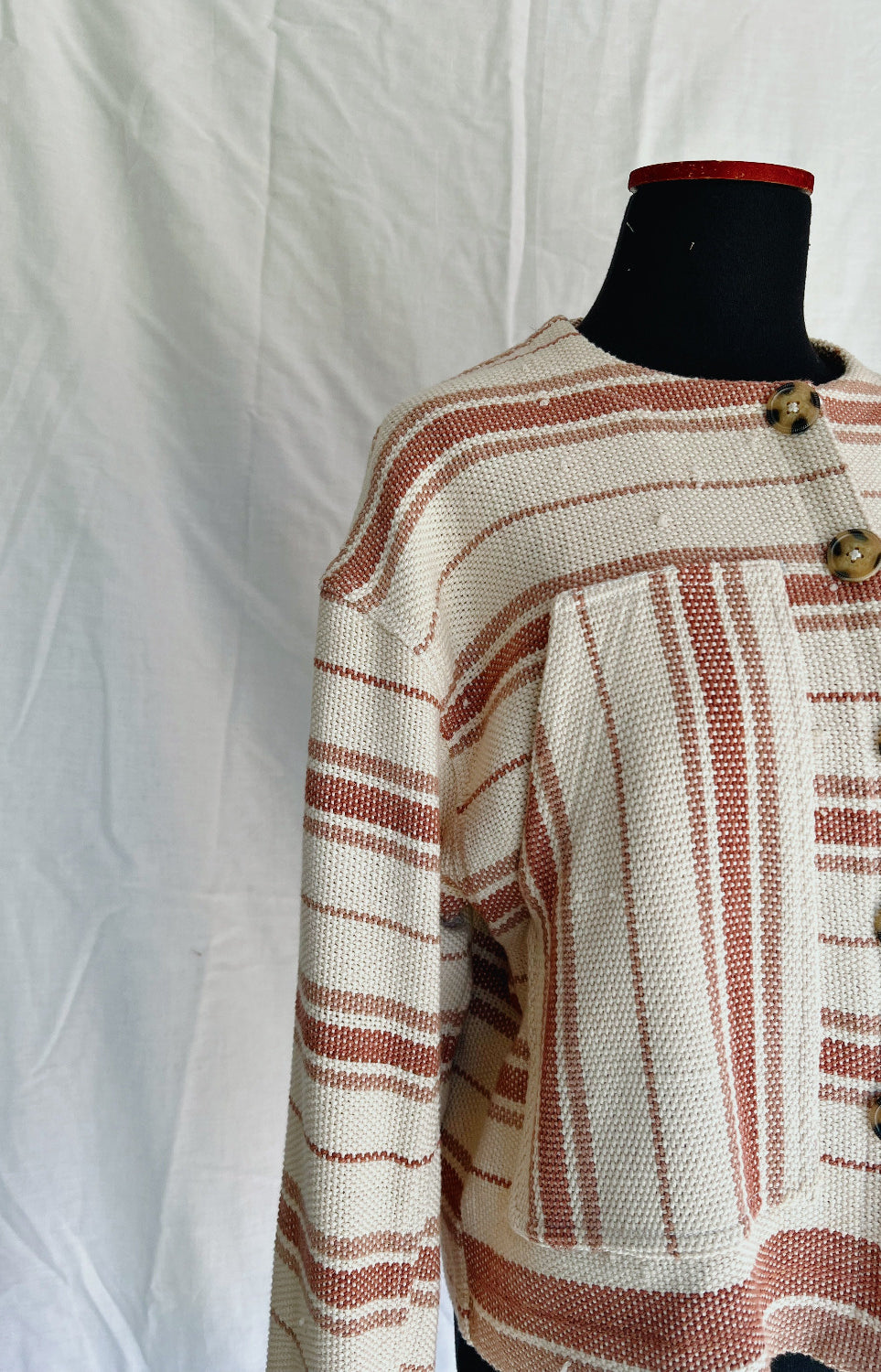 Textured jacket with striped pattern on a mannequin against a white background