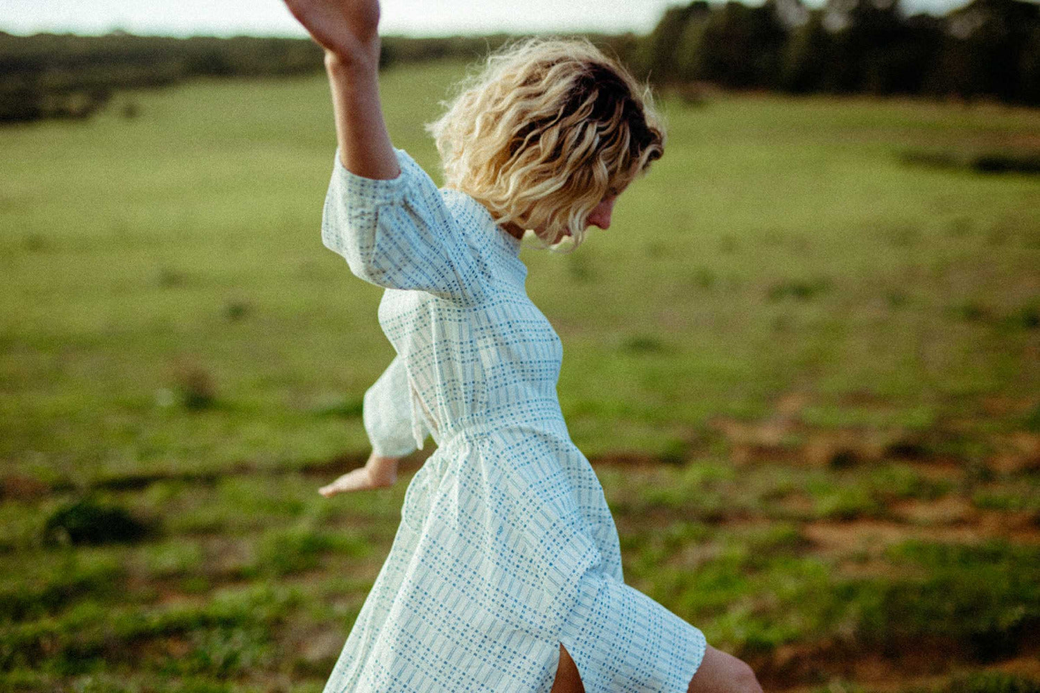 Woman moving freely in a lightweight RŪPAHAUS dress, designed for everyday comfort and modern life