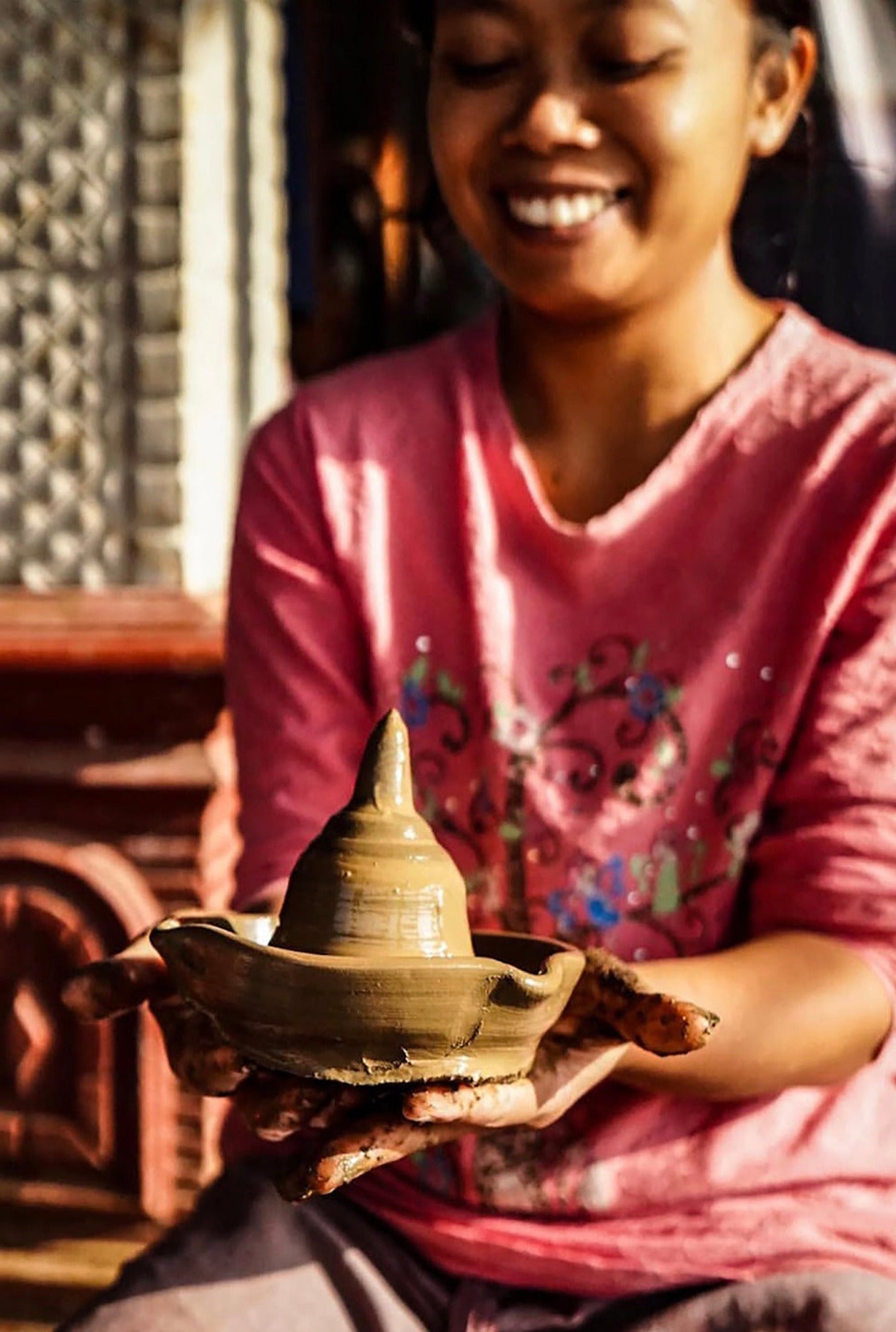 Klipoh pottery artisan holding a freshly shaped handmade clay vessel