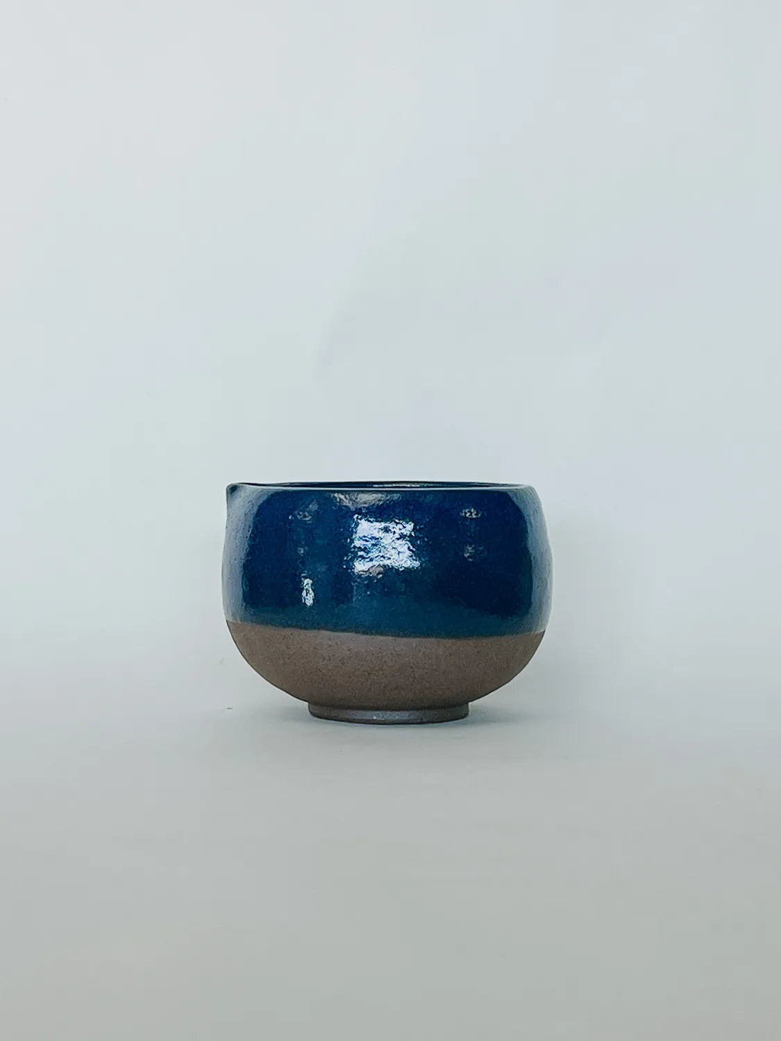 Ceramic bowl with blue top and brown bottom on a white background