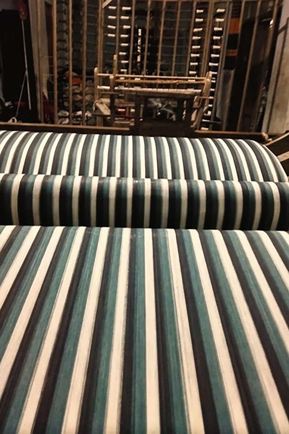 Striped fabric rolled on a loom, showing consistent structure and uniform repetition