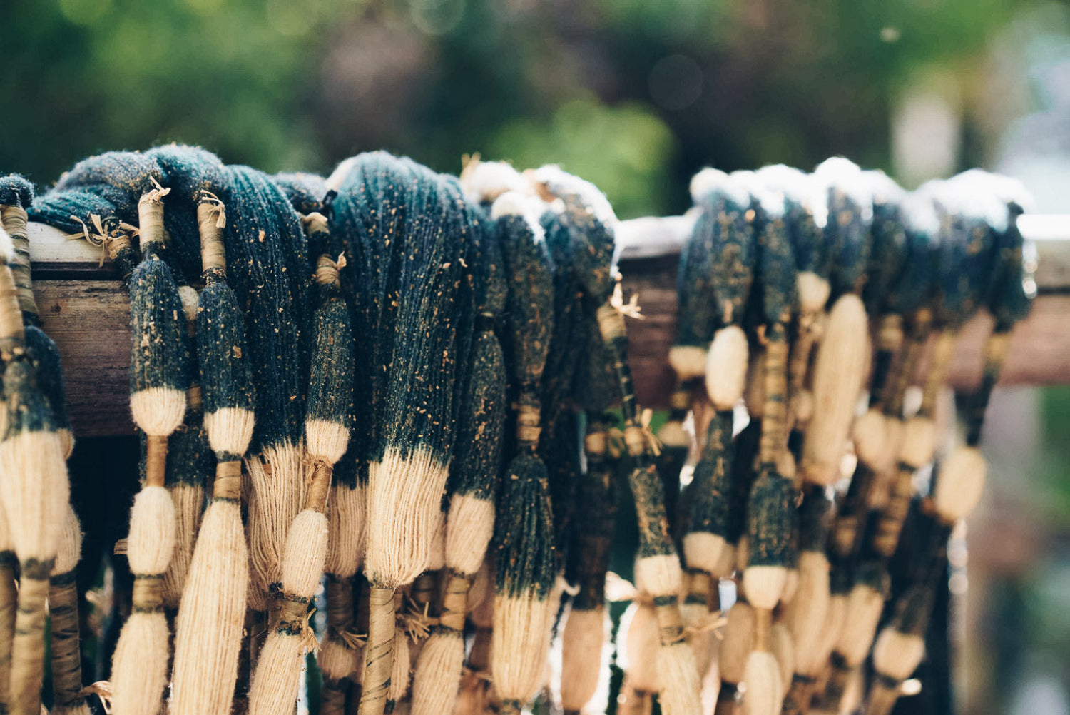Plant-dyed cotton yarn sun-drying outdoors in Indonesia, showing natural colour variation influenced by light and climate