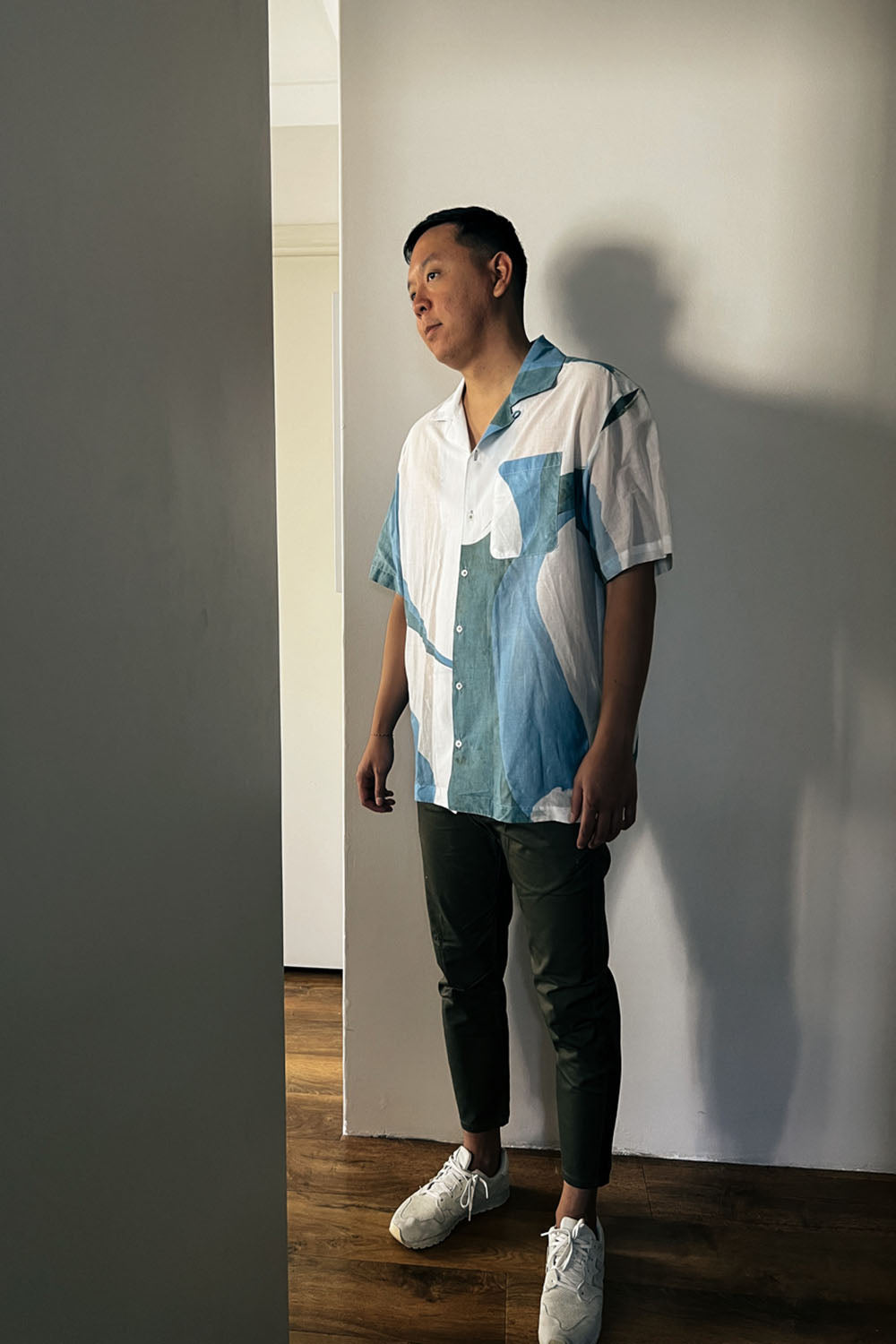 Handpainted Batik Camp Shirt in blue, green and natural hues with relaxed collar and short sleeves, worn by a male model