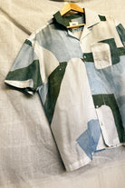 Handpainted Batik Camp Shirt in blue, green and natural hues with relaxed collar and short sleeves, worn by a male model