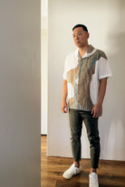 A handpainted batik cotton shirt in beige, brown, and white colors, worn by a male model