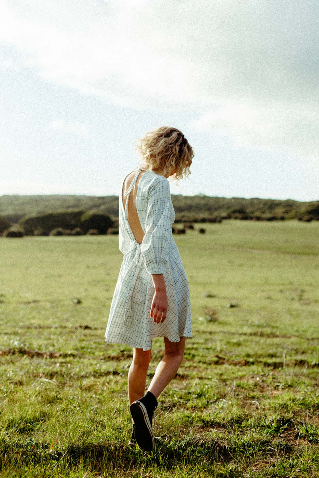 Person walking outdoors wearing a seasonless natural fibre dress, designed for everyday comfort and longevity.