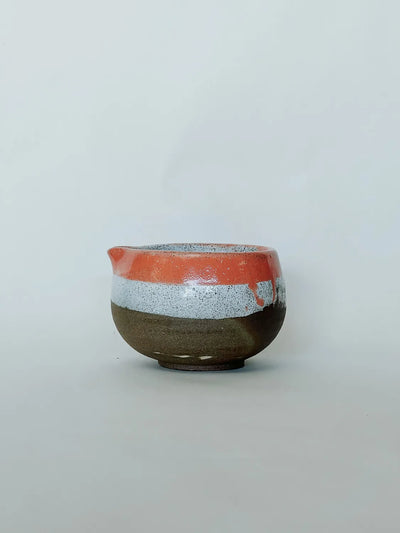 Ceramic bowl with multicolored glaze on a light gray background