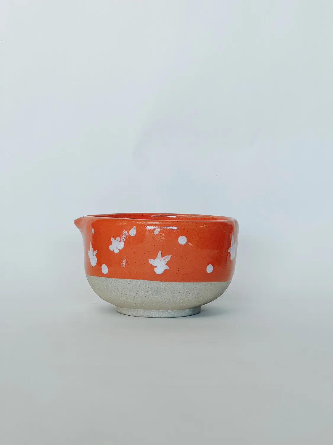 Ceramic bowl with white floral patterns on an orange background