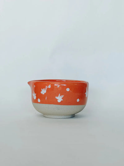 Ceramic bowl with white floral patterns on an orange background