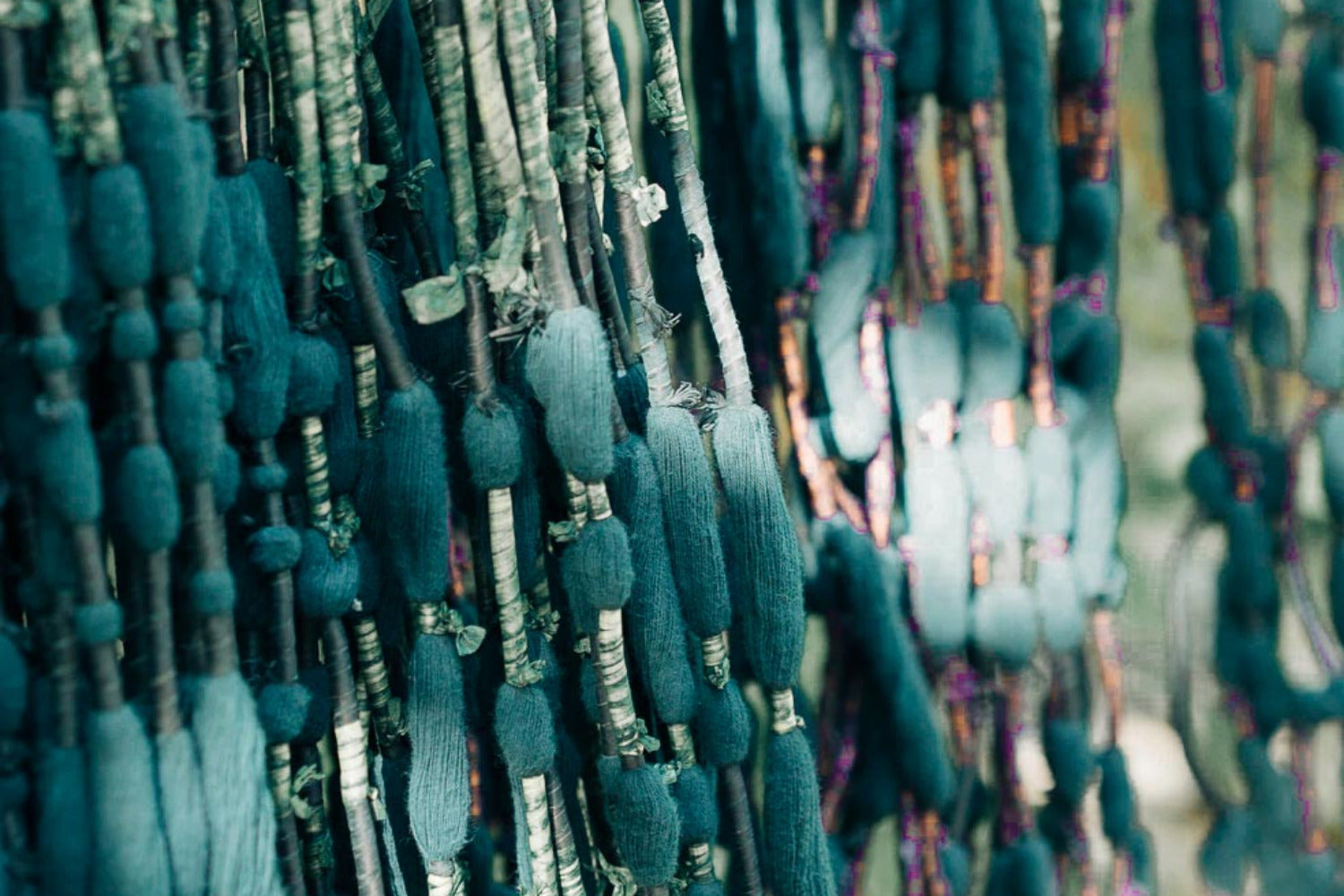 Plant-dyed cotton yarns hanging to dry in natural light, showing time-based craft production shaped by climate and seasonal conditions in Indonesia